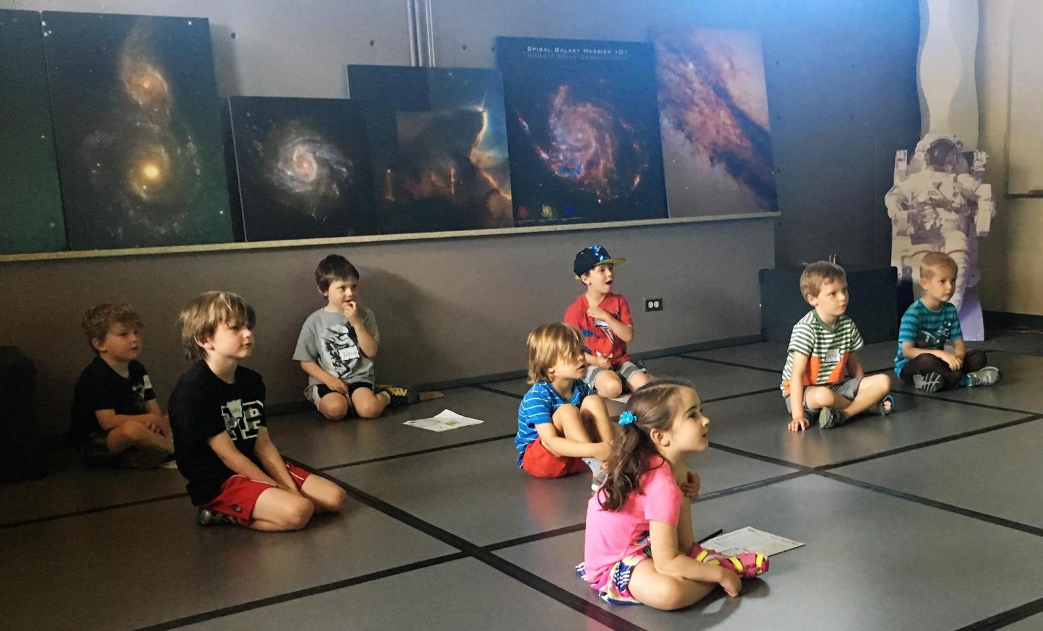 kids listening to speaker in planetarium 