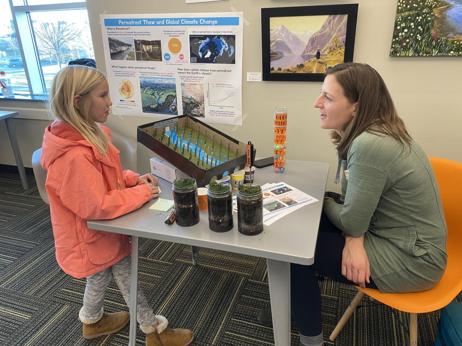scientist talking to small child at outreach event