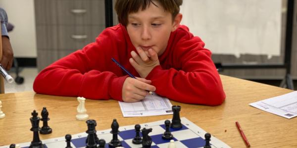 2 students looking at chess board