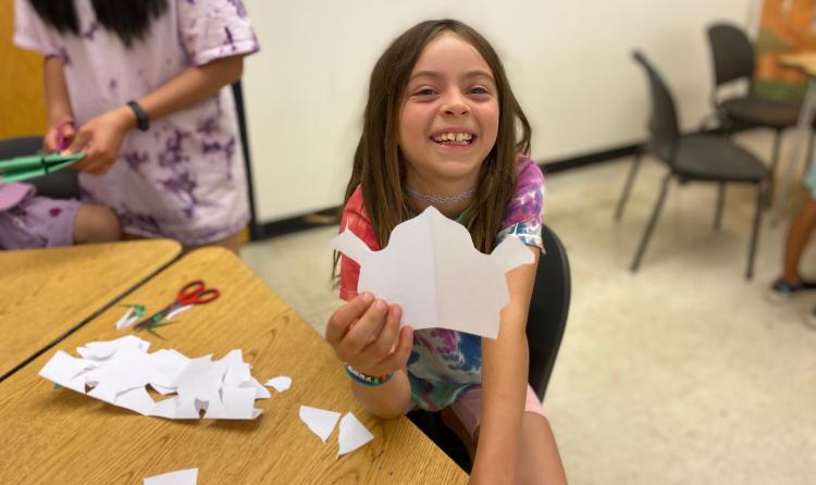 child holding paper cut-out