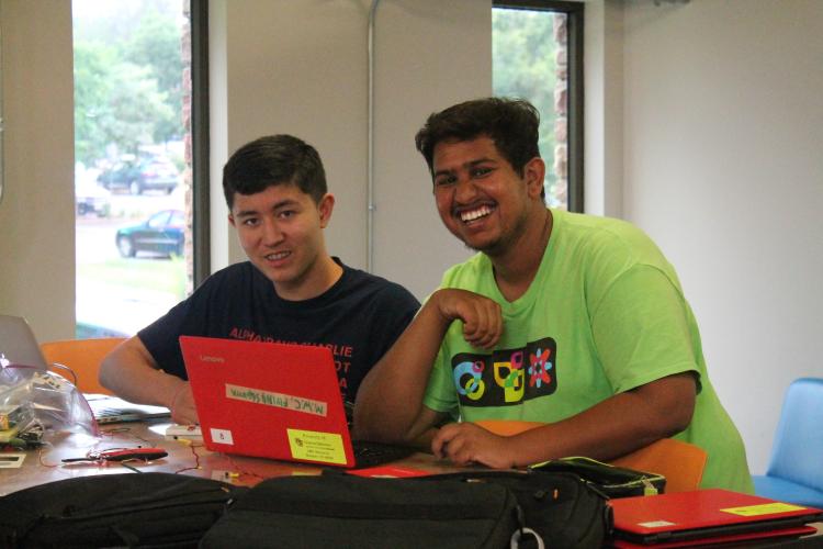 Instructor and student at table working from a computer