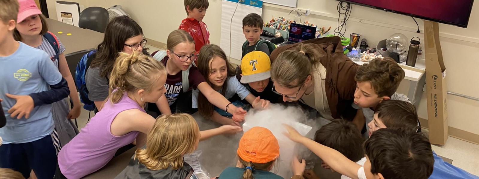 campers gathered around table to observe experiment 