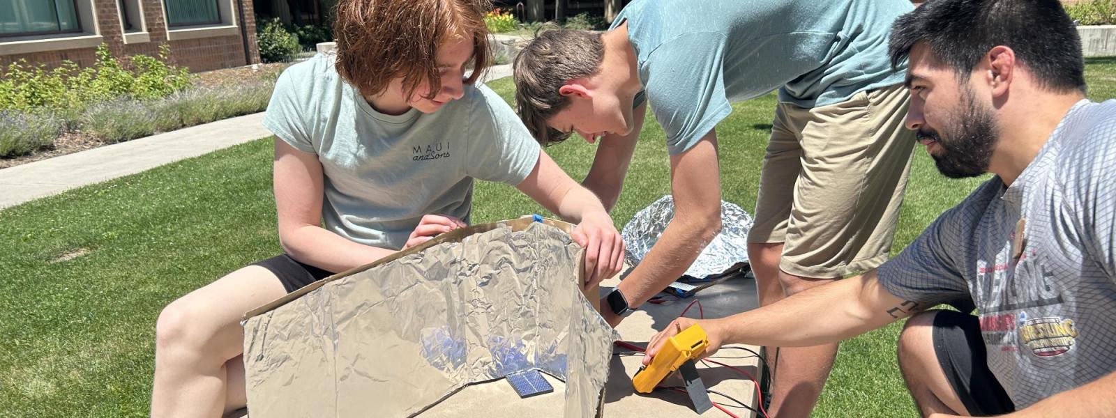 2 students and teacher testing temperature on project 