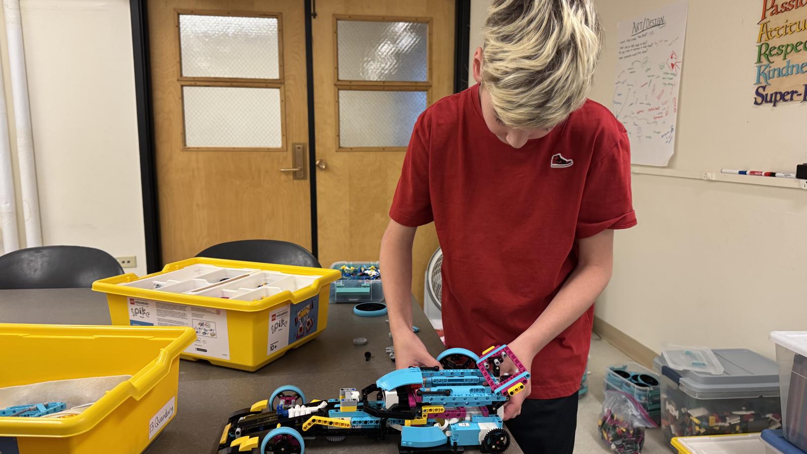 student assembling LEGO robot