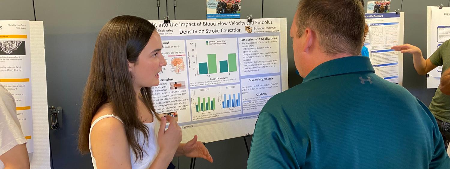 student sharing STEM research experience poster with visitor