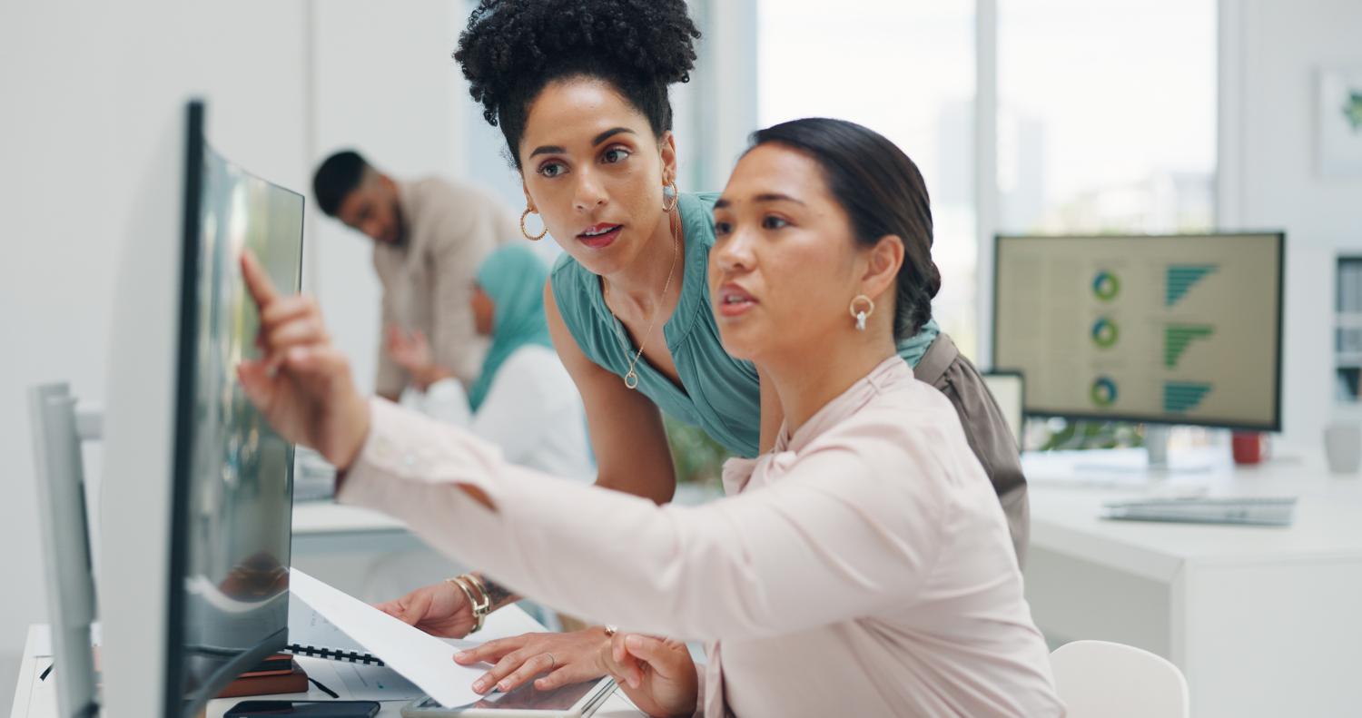 Two women collaborating in front of a computer