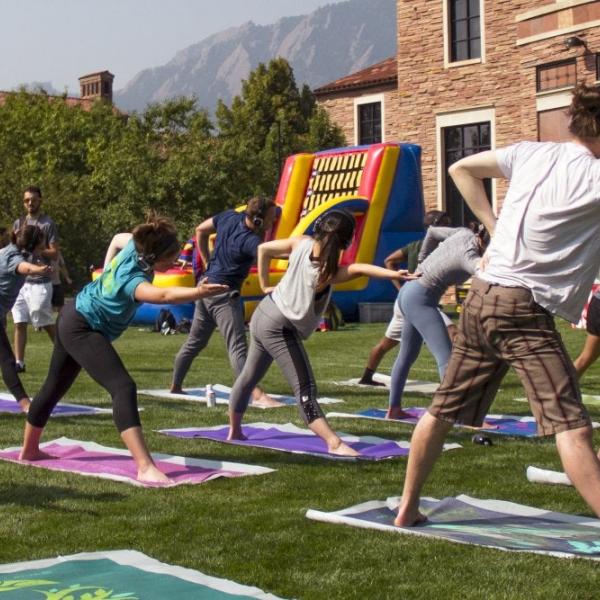 Students taking an outdoor yoga class on campus