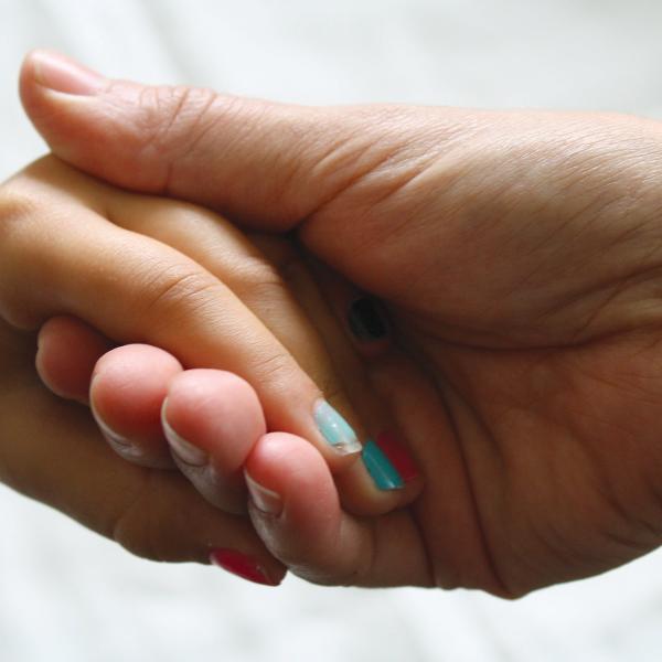 Two hands holding one another