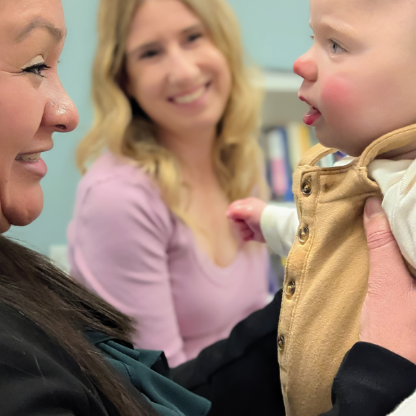 Alma program peer mentors Gracia Deras, left, and Shannon Beckner sit with baby Wyatt