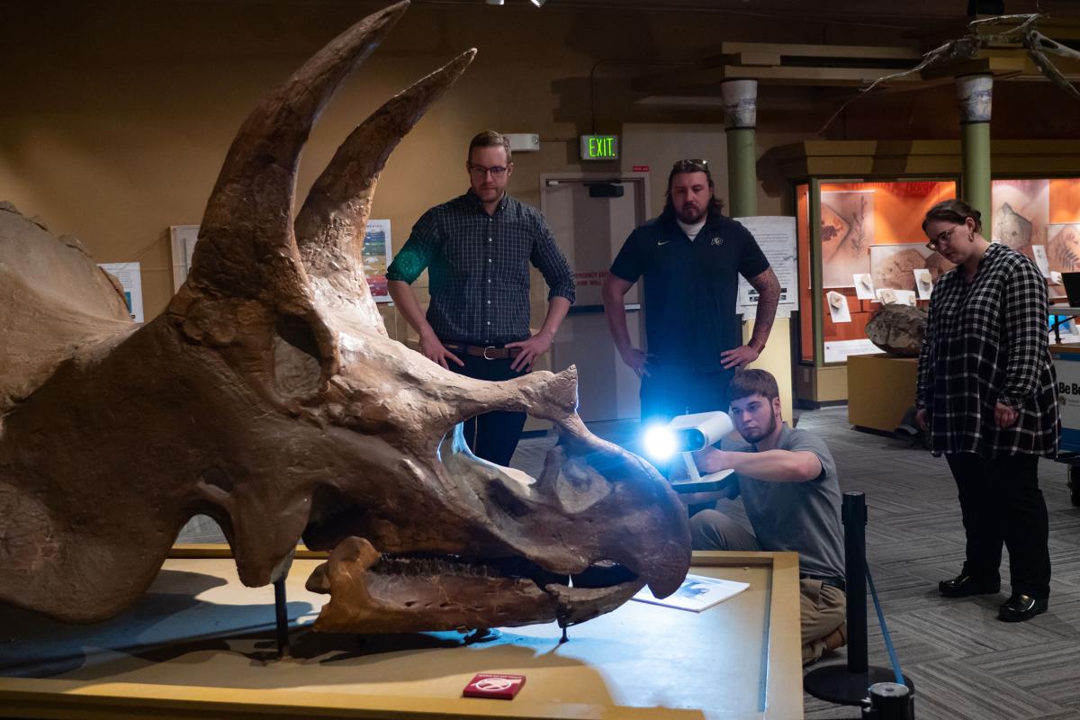 Students with dinosaur skull