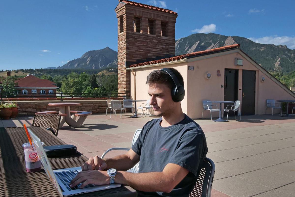 Student on laptop outside on campus