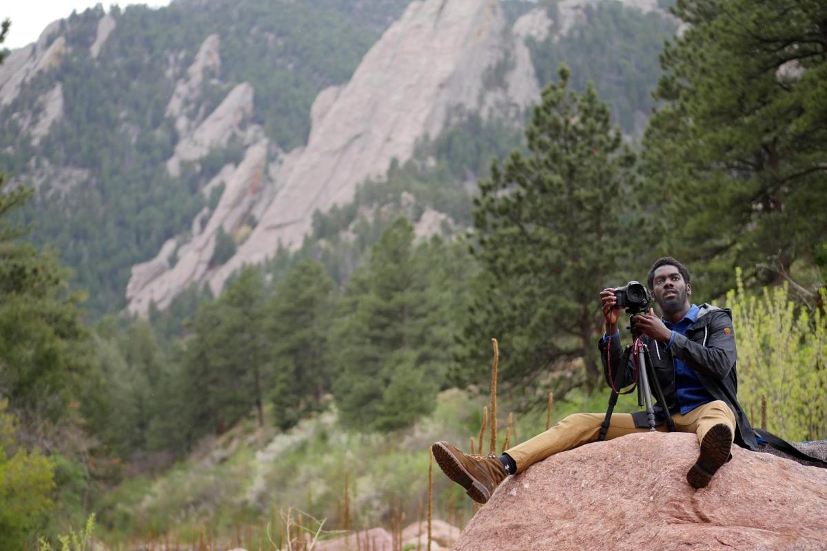 Student with camera in the mountains