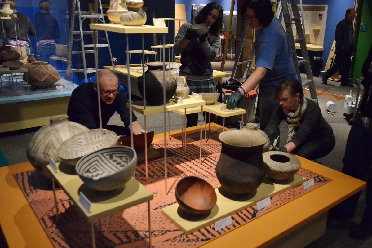 People looking at museum pottery