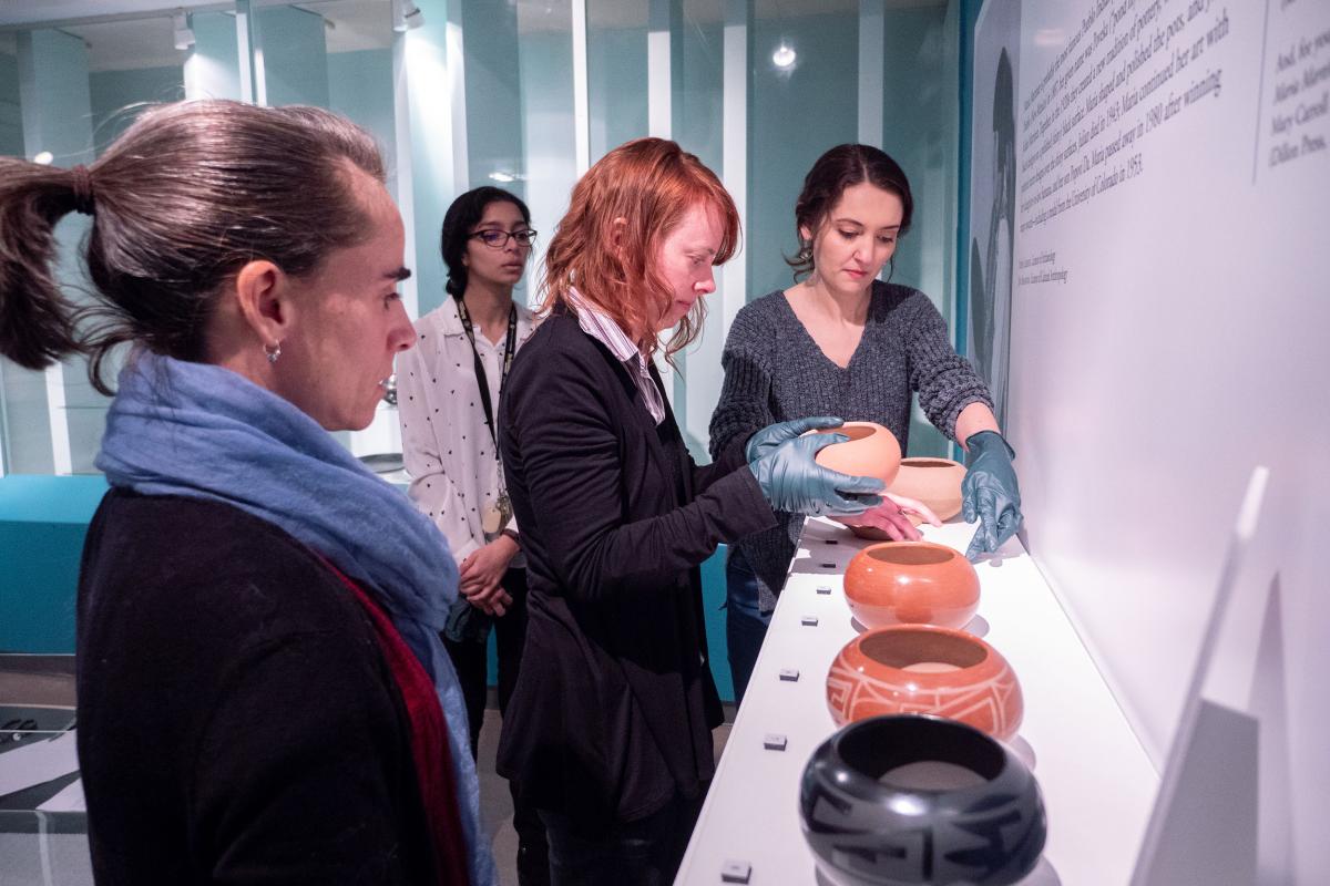 Group looking at pottery bowls