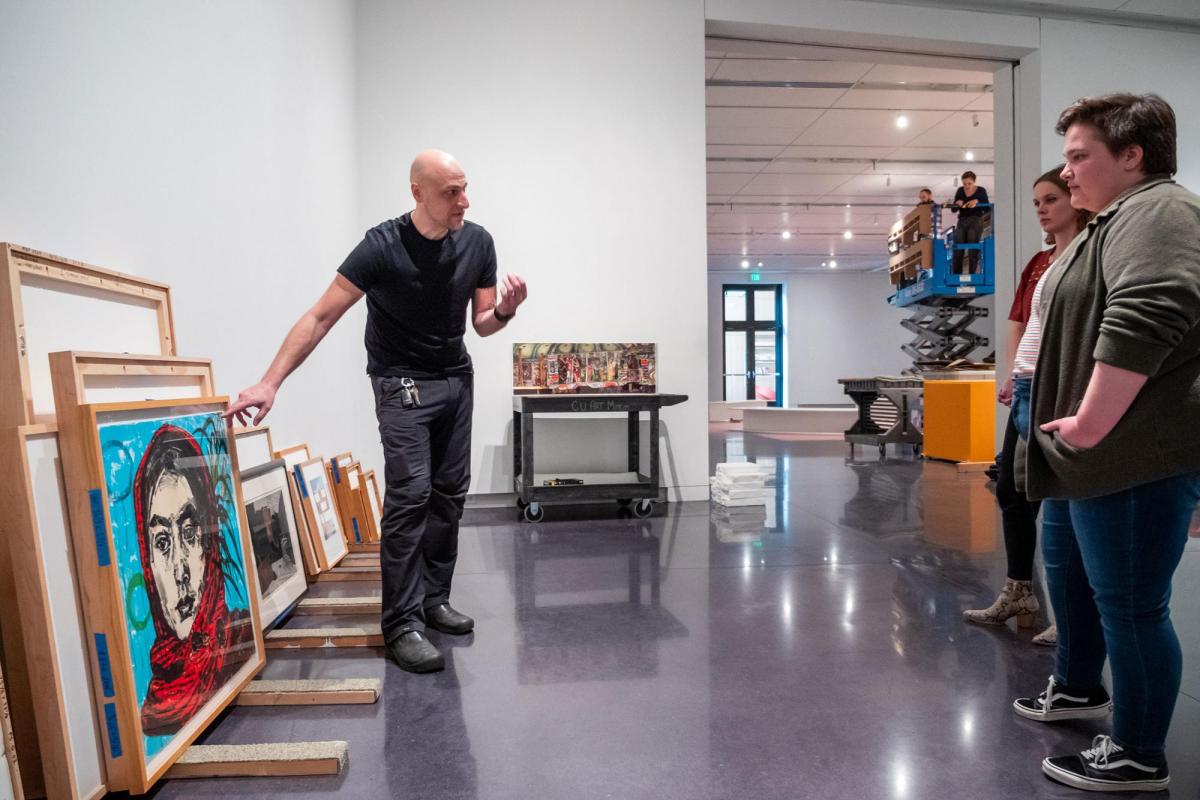 Faculty and students looking at paintings