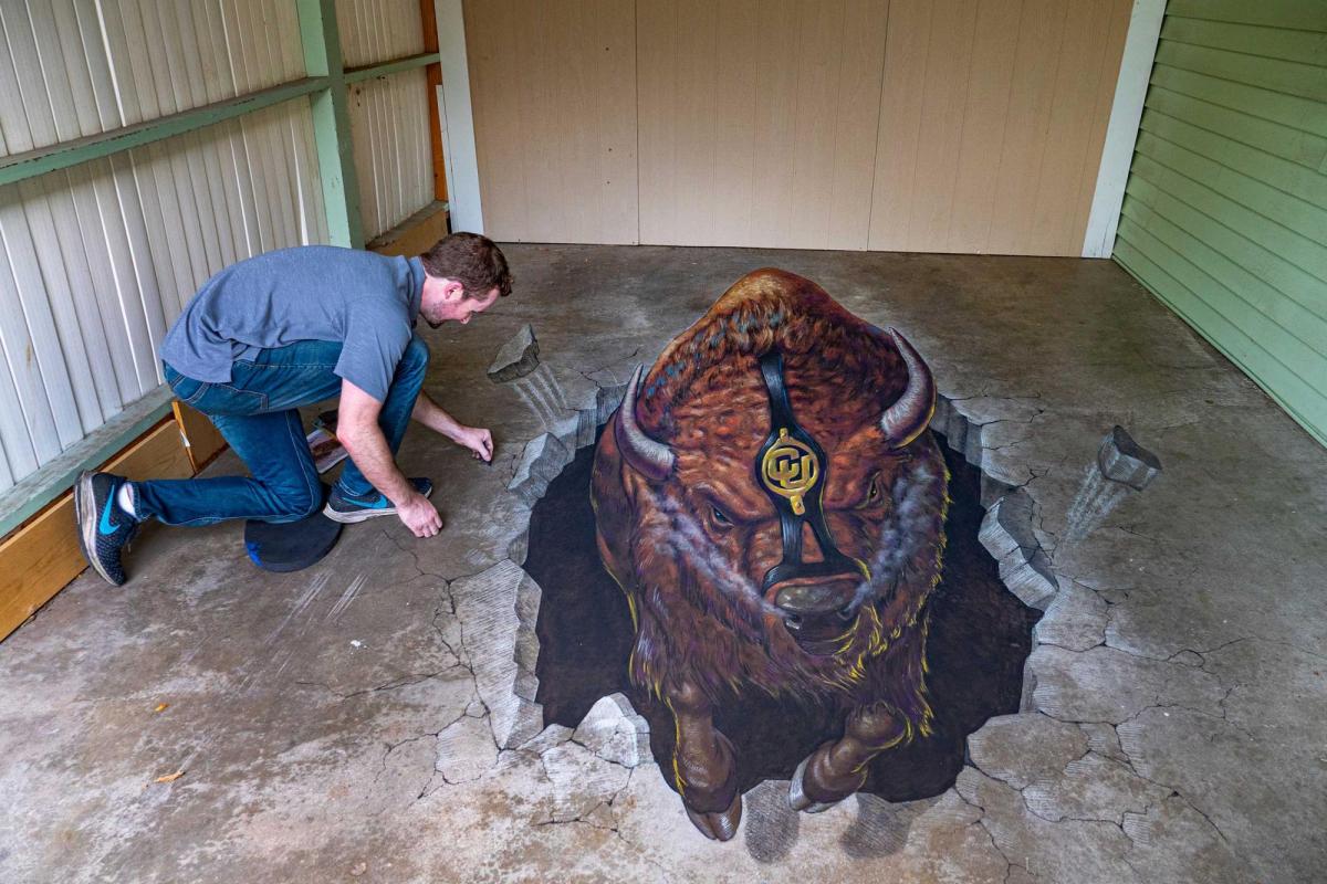 Student creating Ralphie art on cement