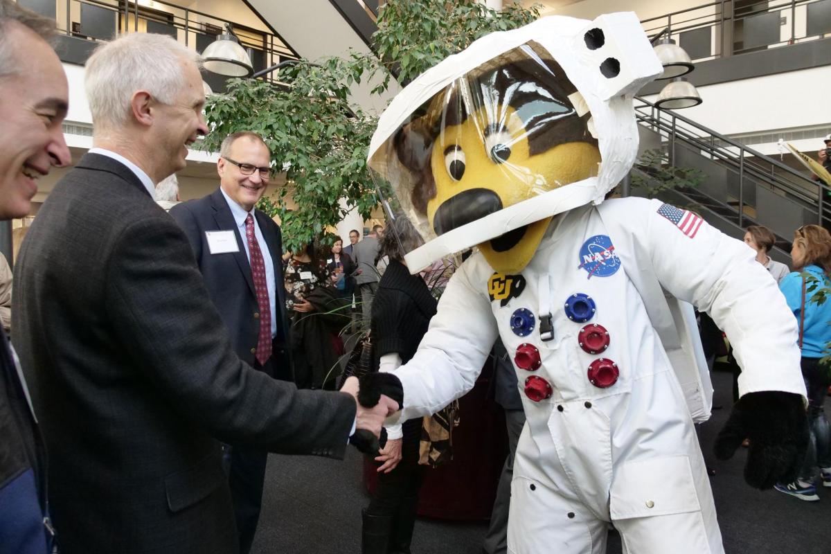 Ralphie mascot in an astronaut suit shaking hands