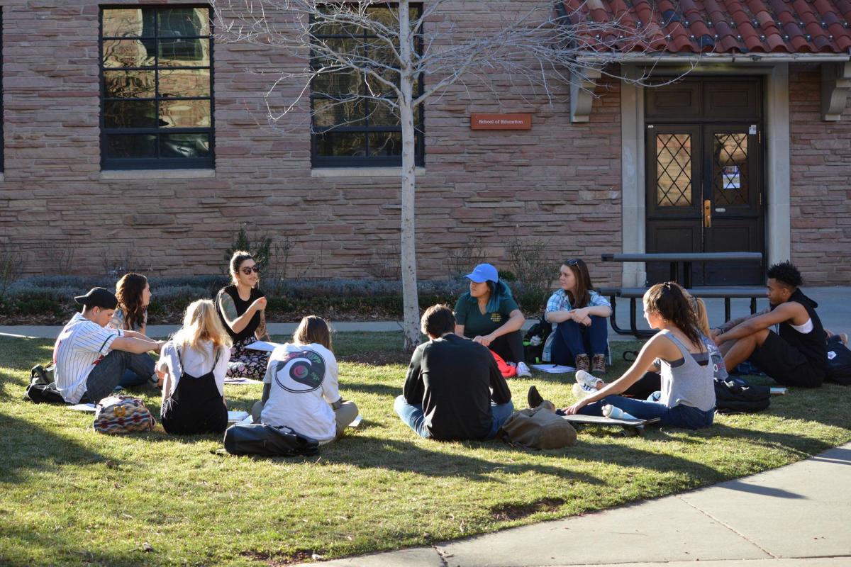 Students attending class outside on lawn