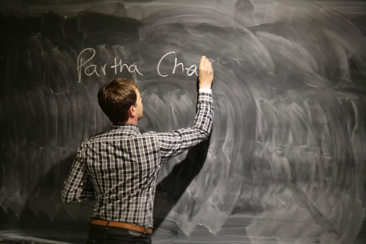Professor writing on chalkboard