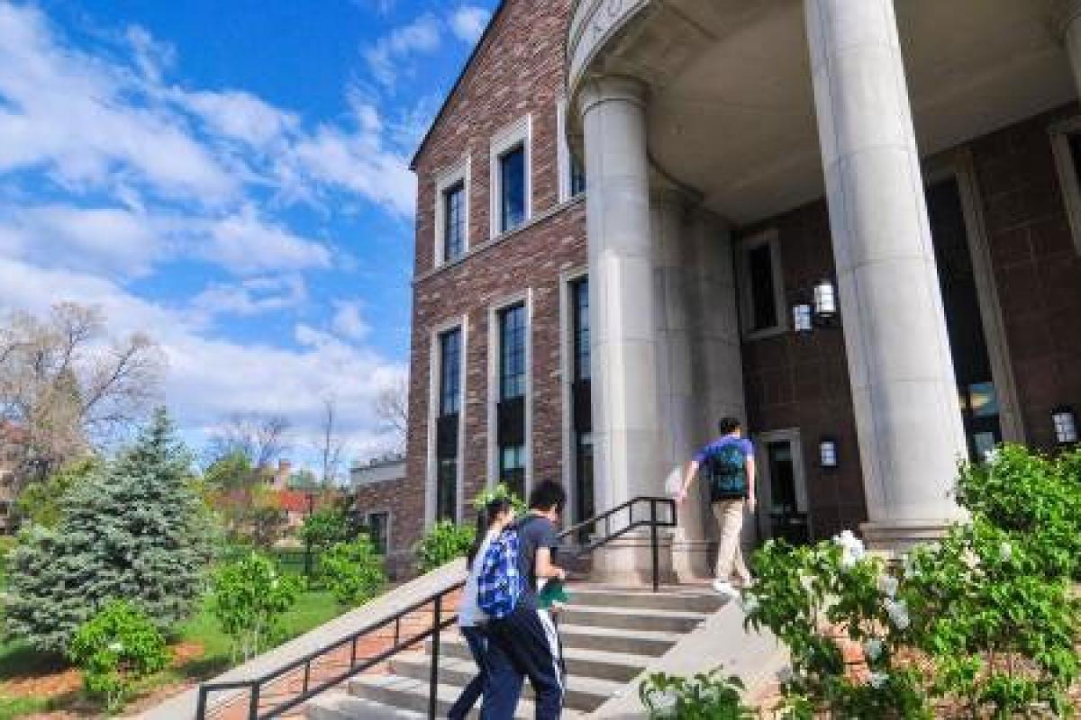 Students walking up steps at entrance of Koelbel building