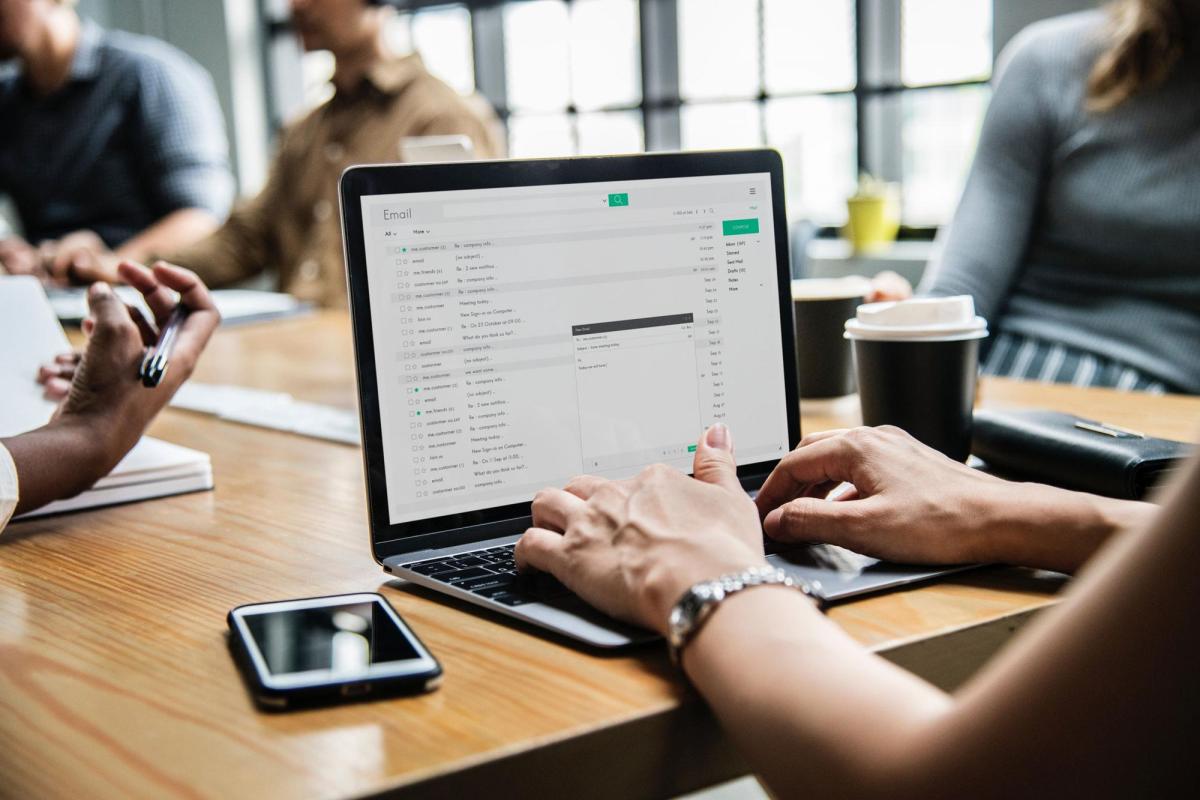 Person at table looking at email on laptop