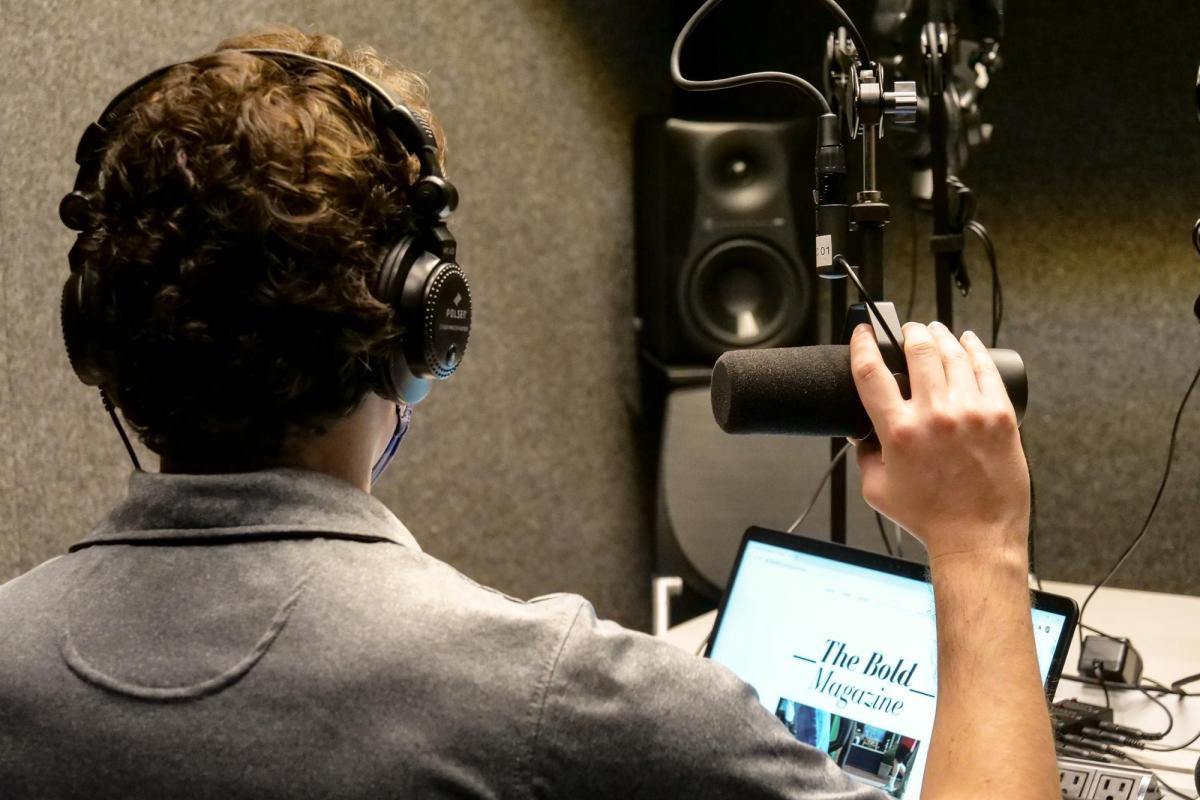 Student recording in podcast booth