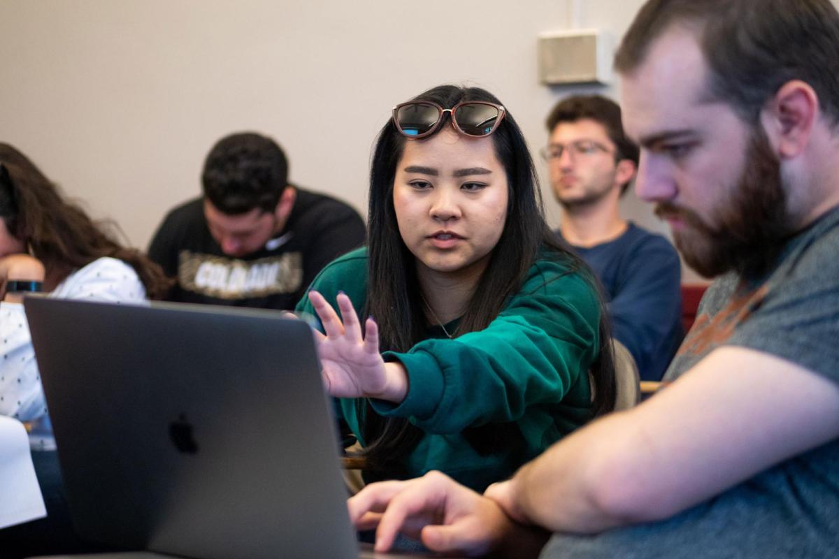 Students looking at laptop in class