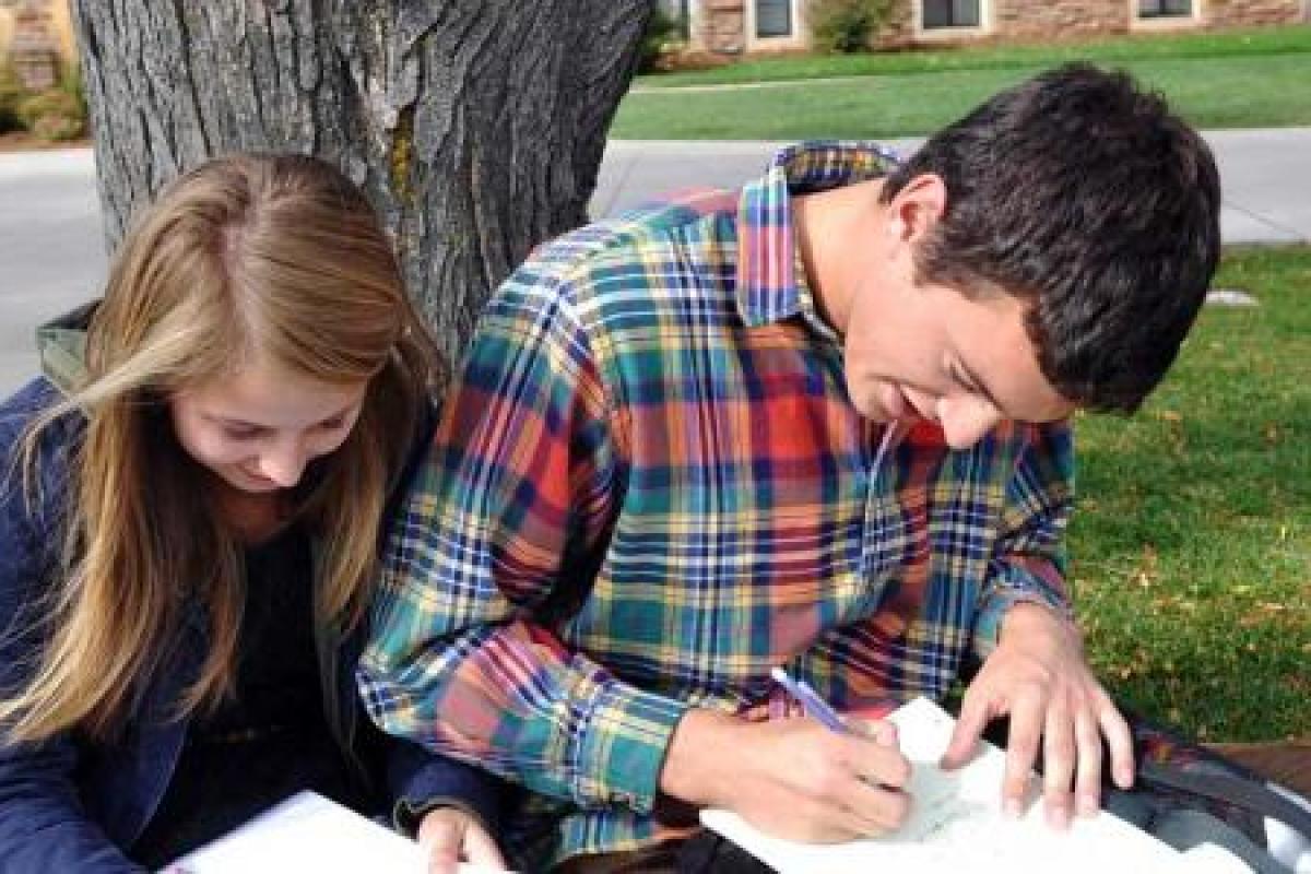 Students outside writing in notebooks