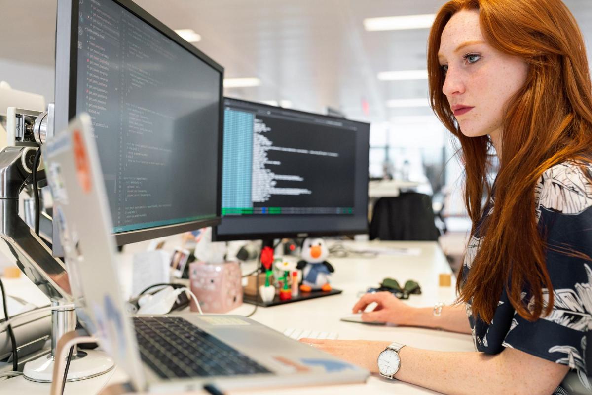 Person working on computer with multiple screens