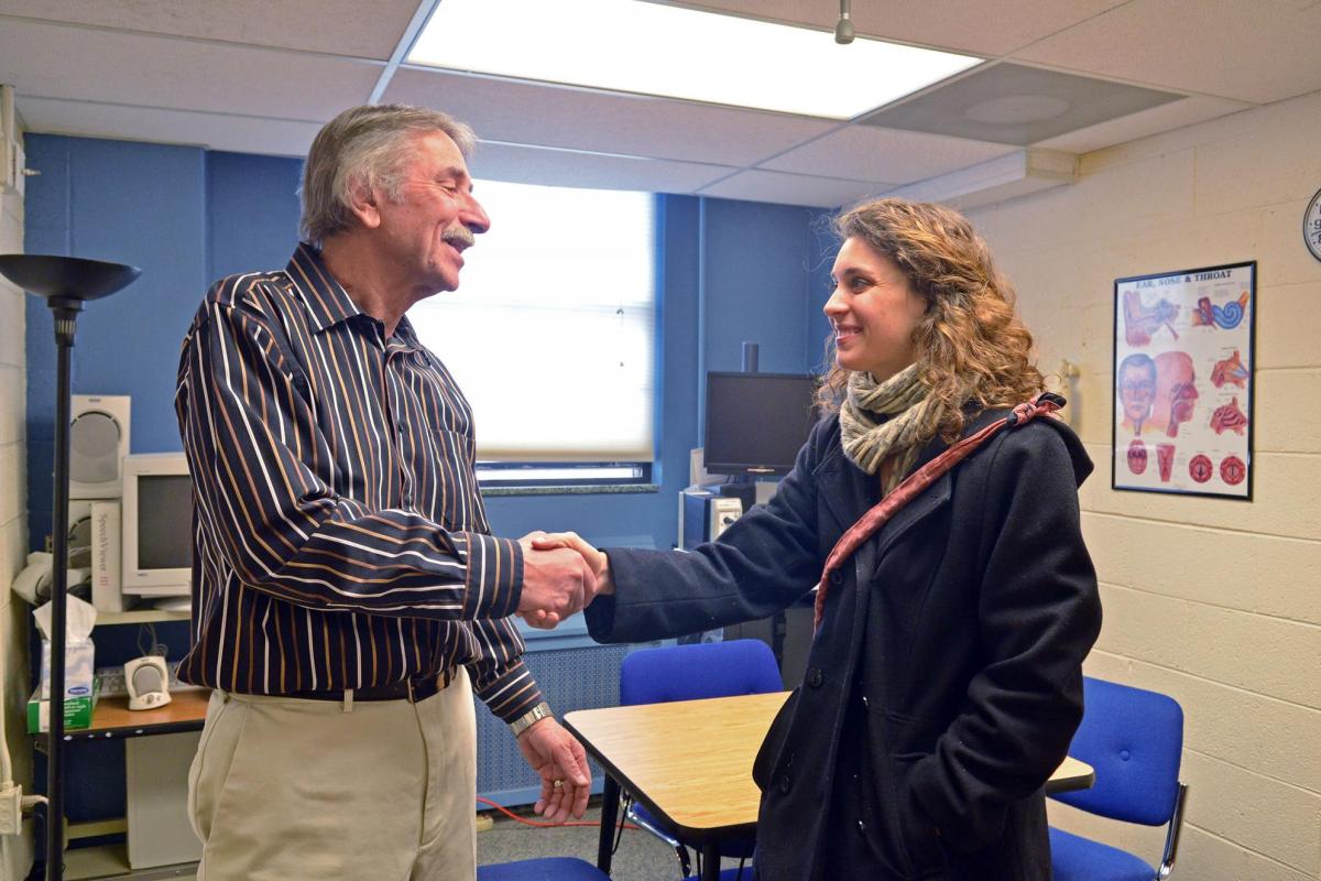 Professor in SLHS shaking hands with person