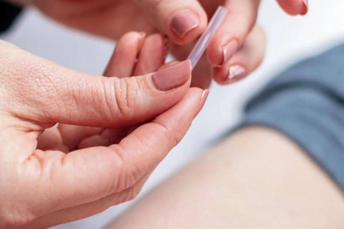 Hand holding a needle in a case