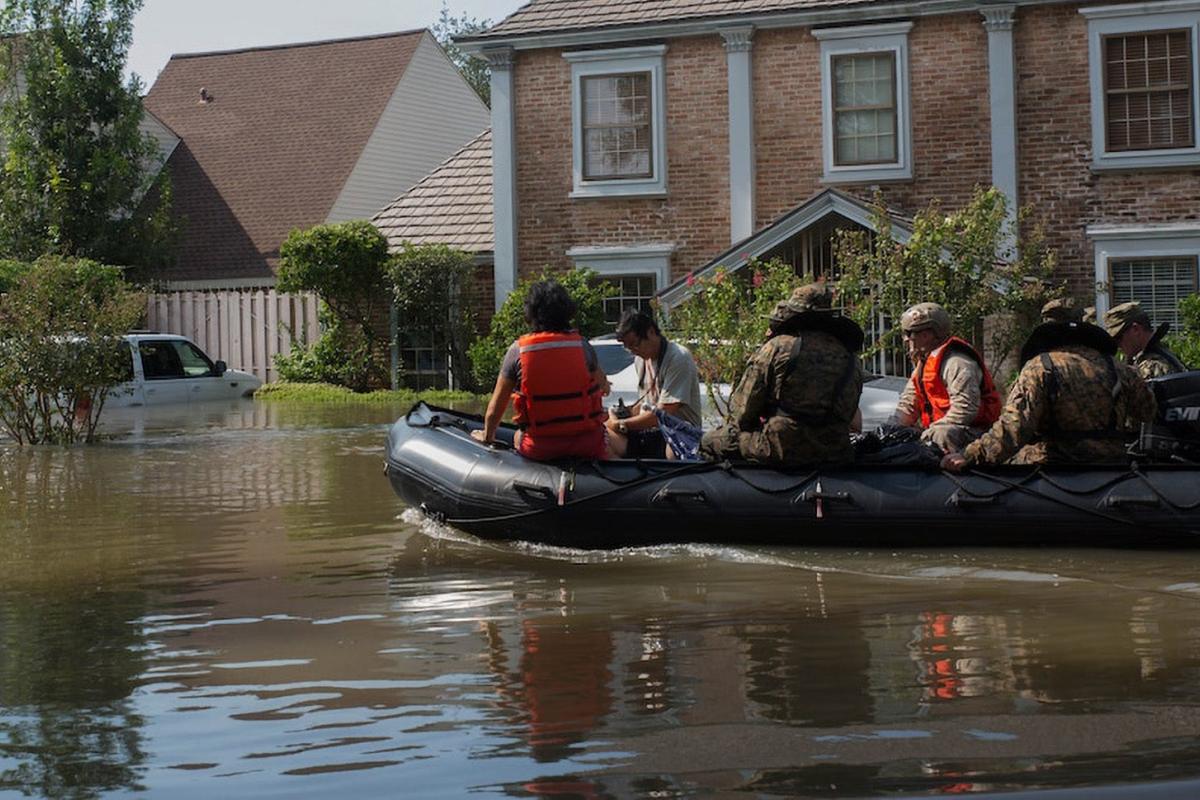 A Marine, a member of the Texas Highway Patrol and Texas State Guard escort a couple to higher ground, Houston, Texas, Aug. 31, 2017.