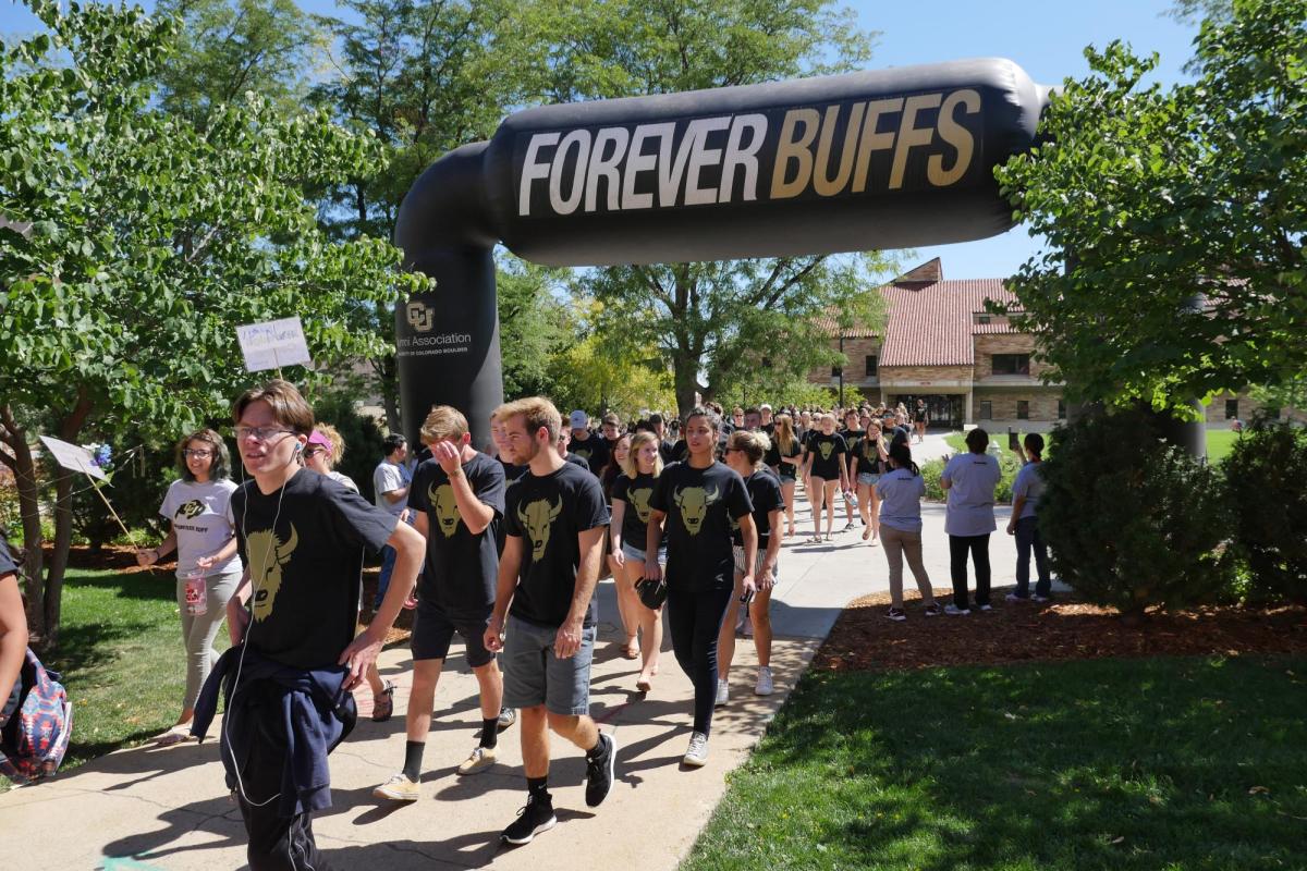 Alums walking under a Forever Buffs banner