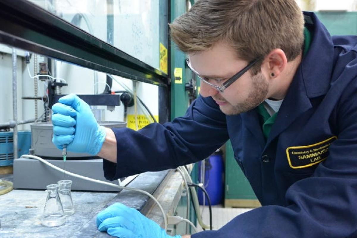 Student working with chemistry beakers in lab
