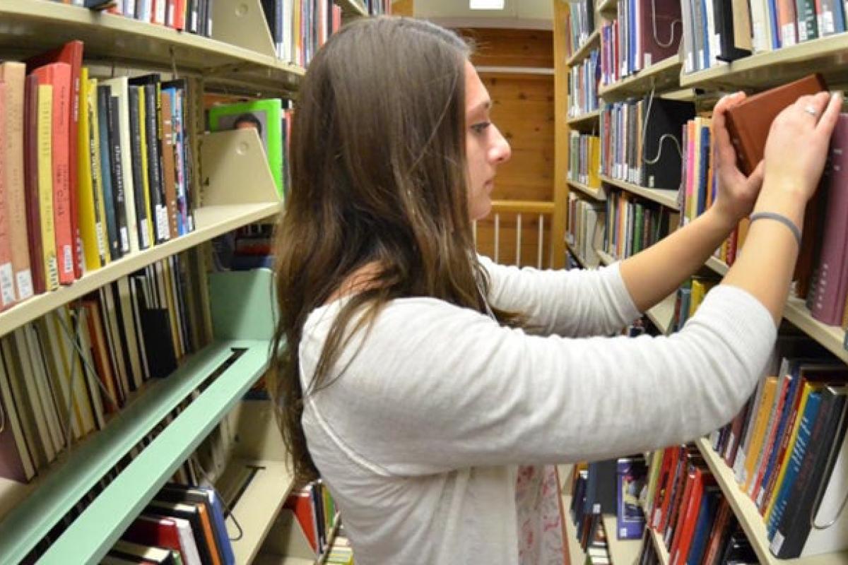 Student searching through the library stacks