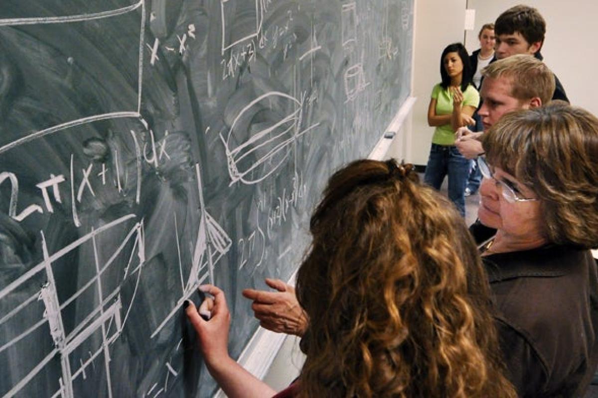 Professor explaining math problem on a chalkboard