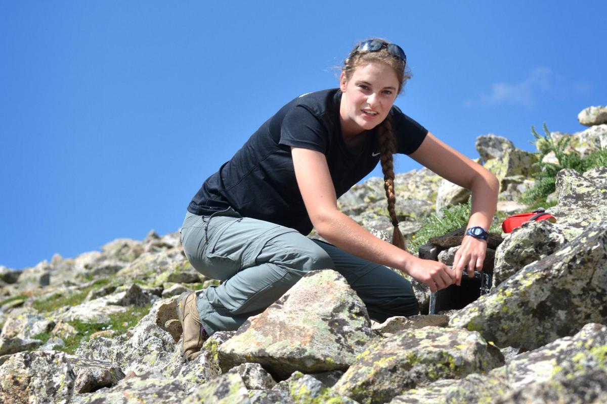 Student conducting research on rocky mountain top