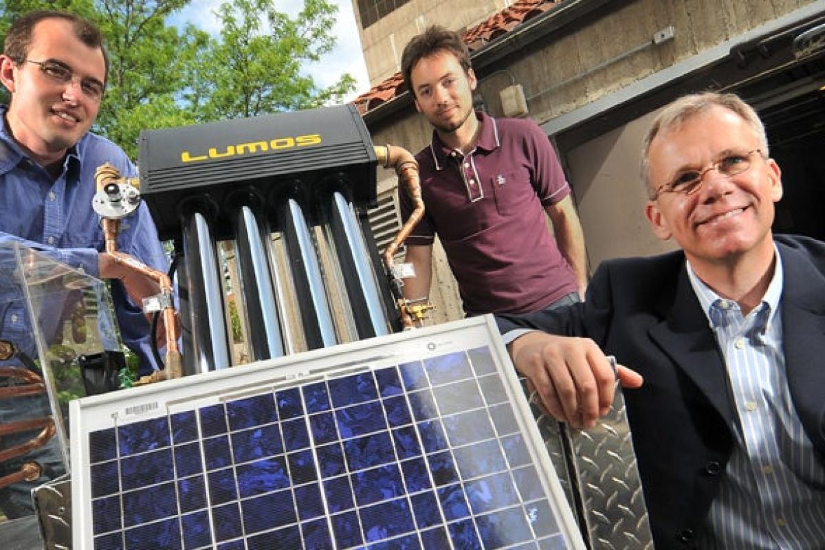 Three men around a solar panel