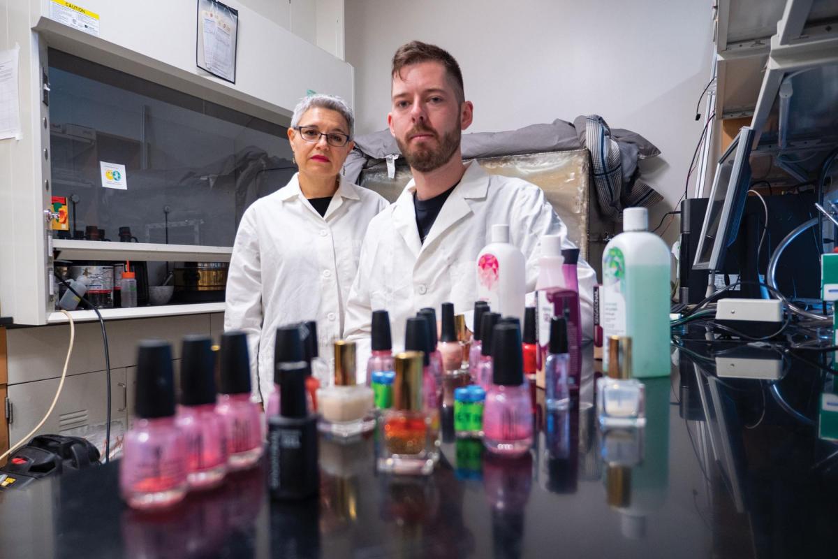 CU Boulder Professor Lupita Montoya and undergraduate student standing behind bottles of nail polish