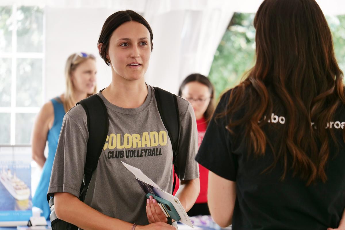 CU Boulder volleyball player talking to Education Abroad staff