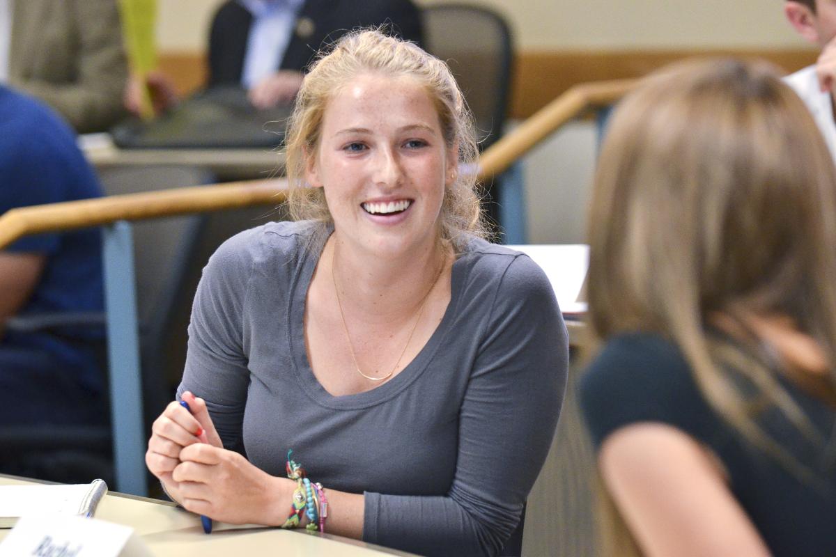 Student smiling as she talks to another student