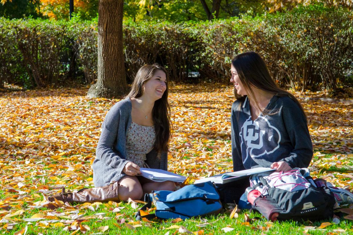 Two students sitting in the quad