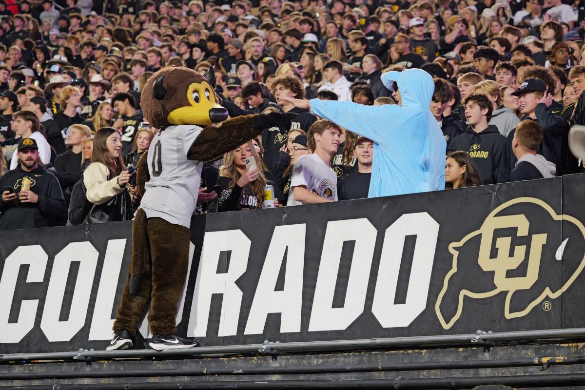 Students in the stand of Folsom Field. Chip the Mascot extends his arm to a student.