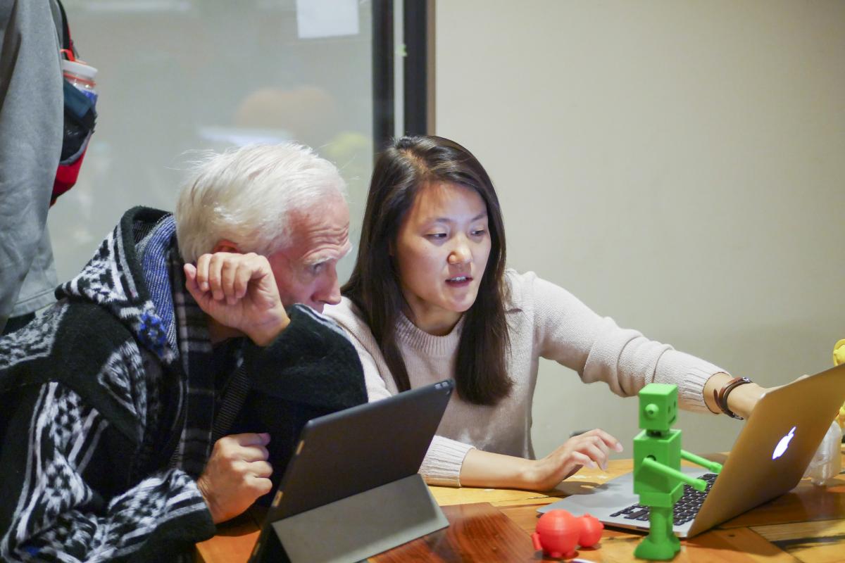 Student and professor looking at a laptop