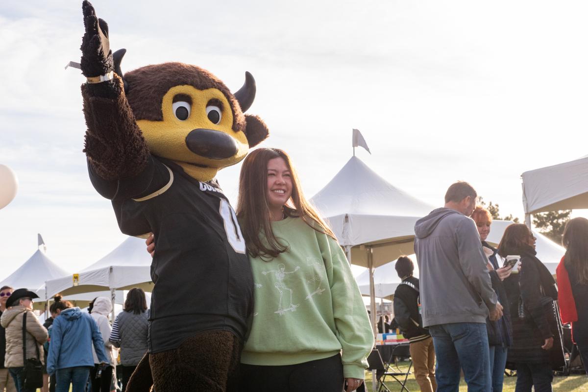 Female student posing with Chip the mascot
