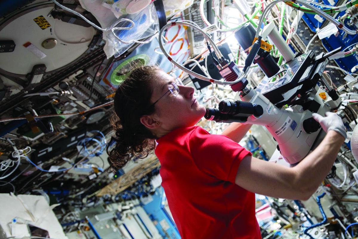 Astronaut Christina Koch uses a microscope supplied by BioServe aboard the International Space Station. 