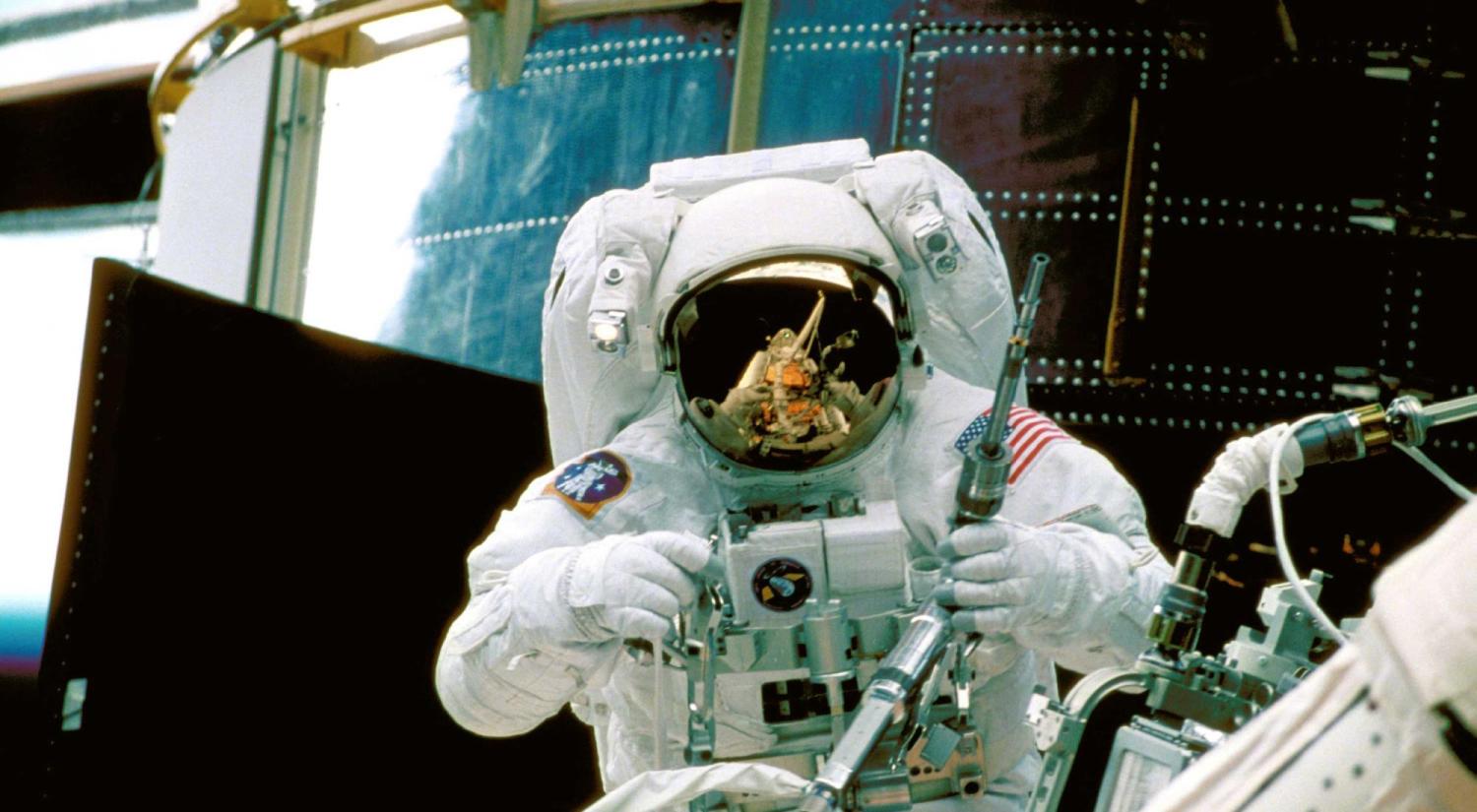 NASA astronaut services the Hubble Space Telescope from orbit in 1997