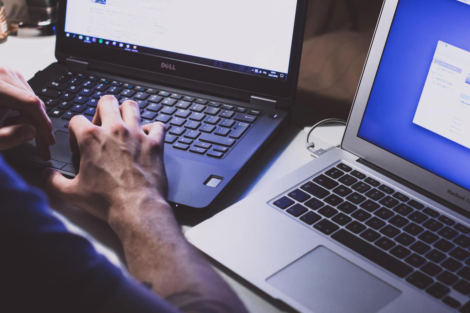 Person on two laptops