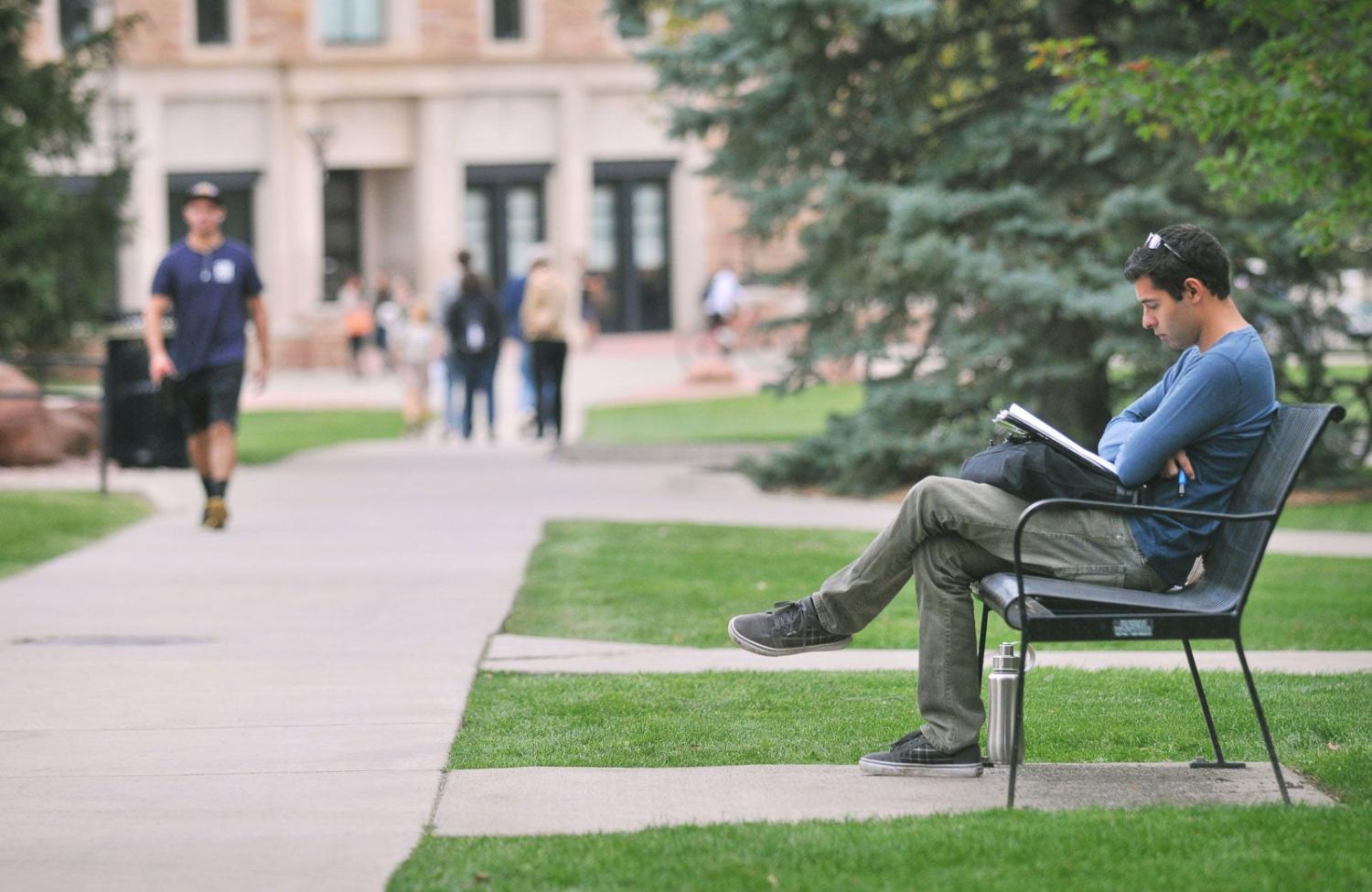 Student with laptop on bench