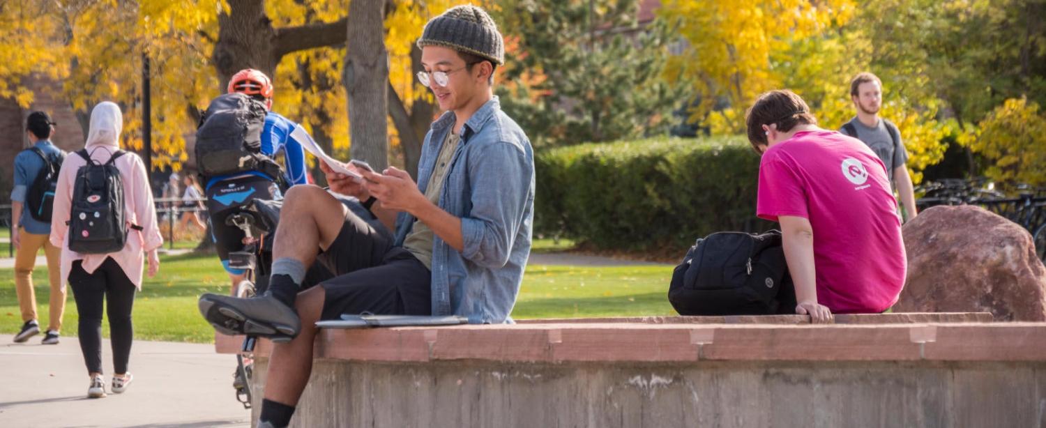 Student sitting outside on a bench